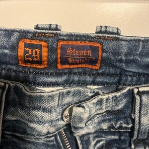 Rock Revival Men's Blue Straight Jeans have been hemmed to a 29” length